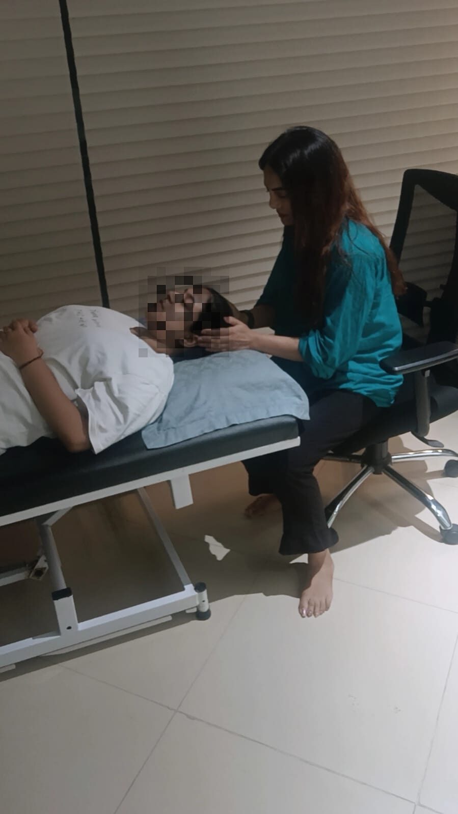 A client resting comfortably on a therapy couch during a guided relaxation session