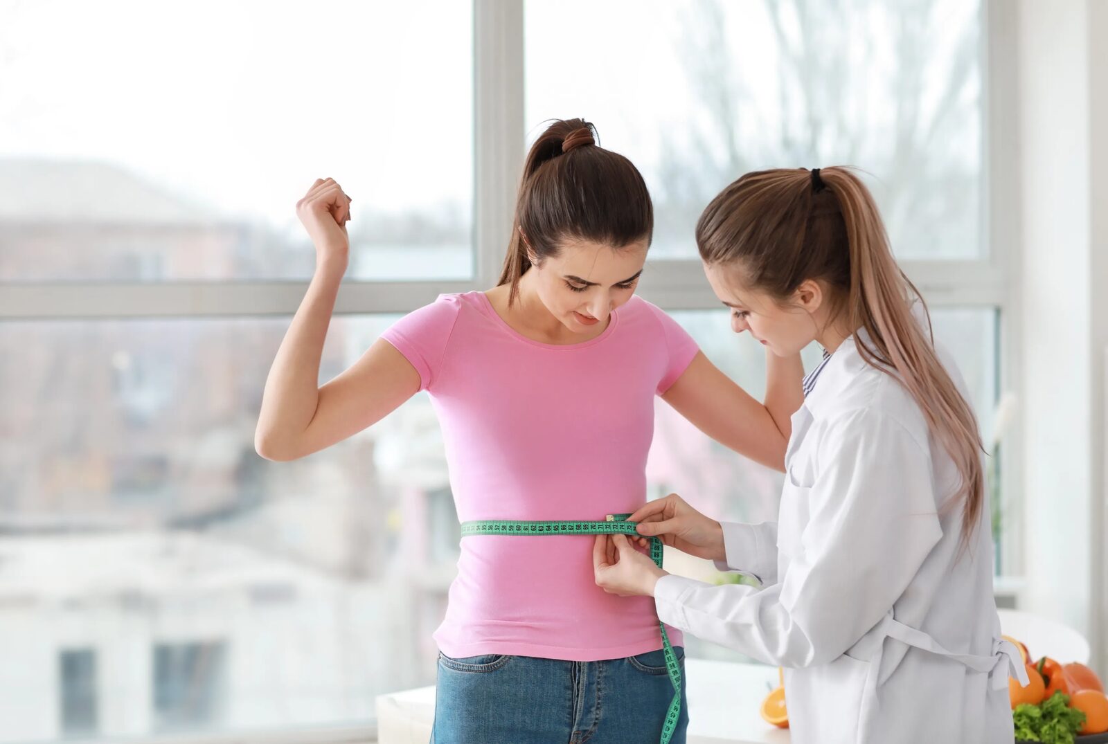 A waist measurement being taken during a routine health review